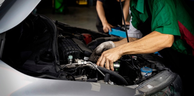 Máquina de cambio automático de aceite. El hombre está cambiando el aceite del motor. Cambie el aceite del motor. Reemplazo del aceite del automóvil. Compruebe el mantenimiento del automóvil. Centro de servicio de reparación de transporte