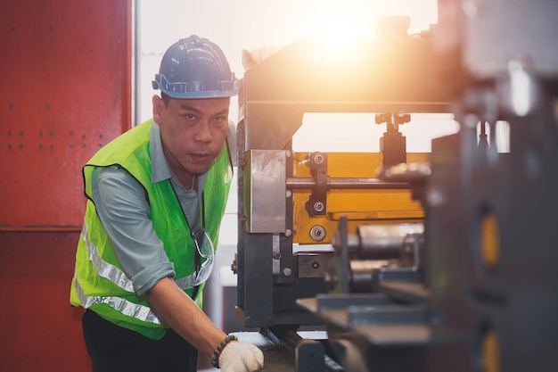 Máquina de control de trabajo de ingeniero asiático en fábrica