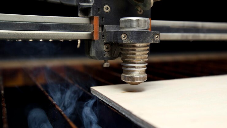Foto la máquina de corte por láser está cortando la tabla de madera.