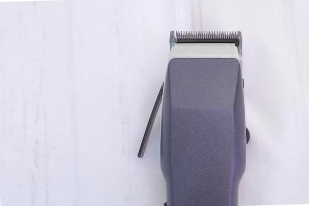 Una máquina de corte de pelo sobre un fondo gris con espacio de copia