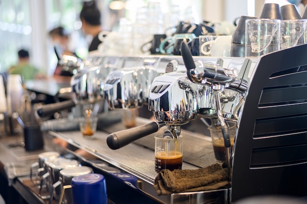 Máquina de café fazendo café puro e servindo em uma xícara no café