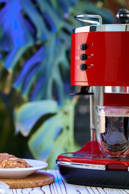 Máquina de café vermelha com um copo no balcão da cozinha