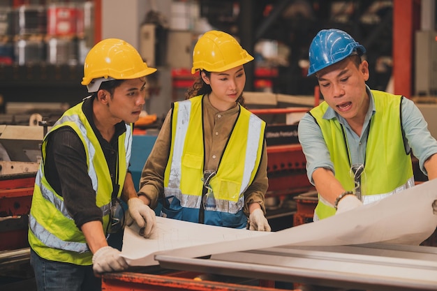 Máquina de controle de trabalho do engenheiro asiático da equipe na fábrica