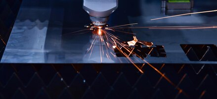 Foto máquina de corte a laser industrial ao cortar a folha de metal com a luz de faísca.copiar o espaço