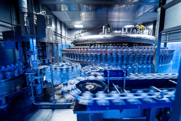 Máquina de enchimento automática derrama água em garrafas pet de plástico em uma fábrica de bebidas moderna