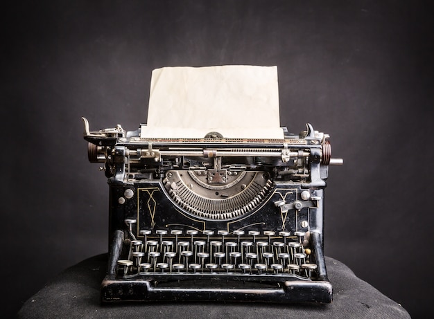 Máquina de escrever vintage preta com folha de papel inserida