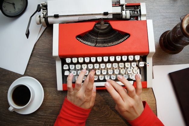 Máquina de escrever vintage vermelha com papel em branco