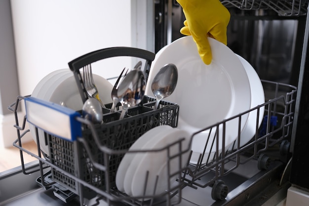 Foto máquina de lavar louça completa com louça lavada. conceito de eletrodomésticos na cozinha