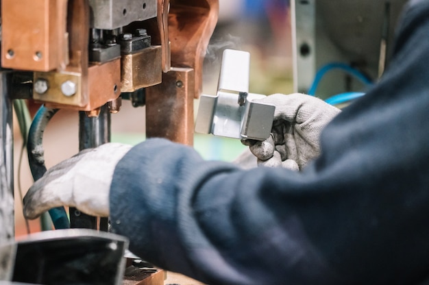 Máquina de solda a ponto Peça automotiva industrial na fábrica. Operador que trabalha na indústria.