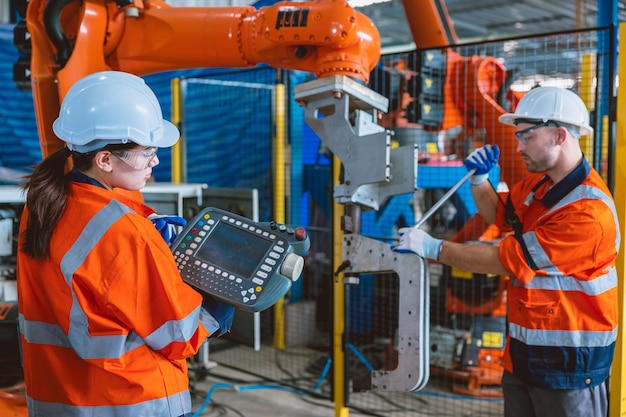 Máquina de ensamblaje de brazo de robot de servicio de trabajador de equipo de ingenieros en fábrica moderna de industria metalúrgica