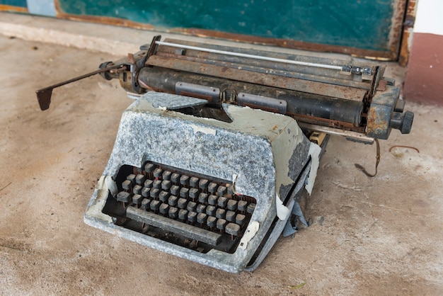 Foto máquina de escribir antigua. foto del primer de la máquina de escribir del vintage en fondo del cemento.