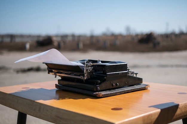 Máquina de escribir en la mesa al aire libre, estuario en el fondo