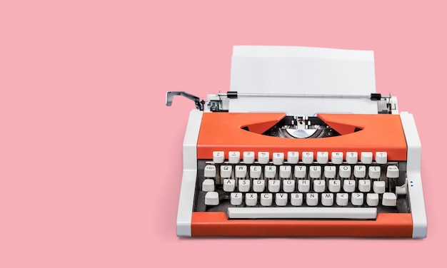 Una máquina de escribir sobre una mesa rosa.