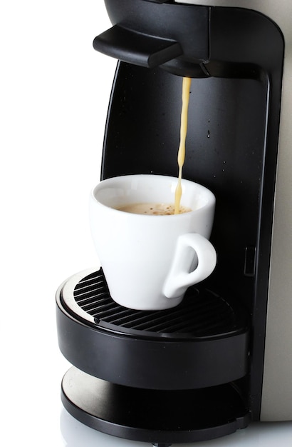 Máquina de espresso vertiendo café en una taza aislada en blanco