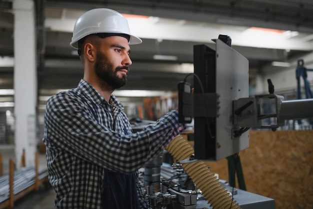 Foto máquina de funcionamiento del trabajador en la fábrica.