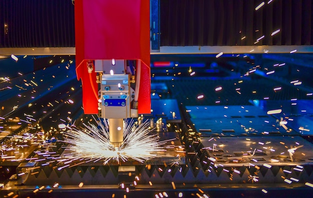 Máquina industrial de corte por láser mientras corta la chapa con la luz chispeante