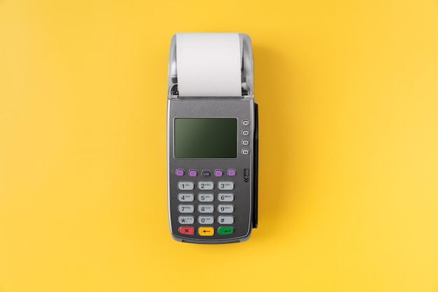Máquina leitora de cartão com fatura em fundo amarelo conceito de pagamento online