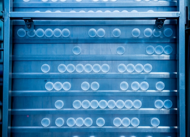 La máquina de llenado automática vierte agua en botellas de plástico para mascotas en una moderna planta de bebidas