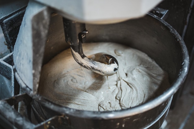 Máquina mezcladora de masa eléctrica en la cocina de la panadería Está mezclando masa fermentada