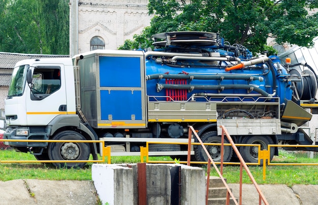 Máquina de servicios públicos para la limpieza de aguas residuales urbanas cerca del tanque con aguas residuales urbanas