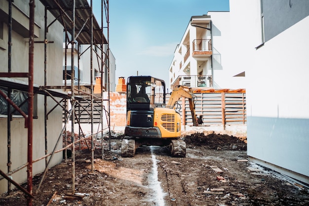 Maquinaria industrial no canteiro de obras Mini escavadeira pesada movendo terra para construção de fundações