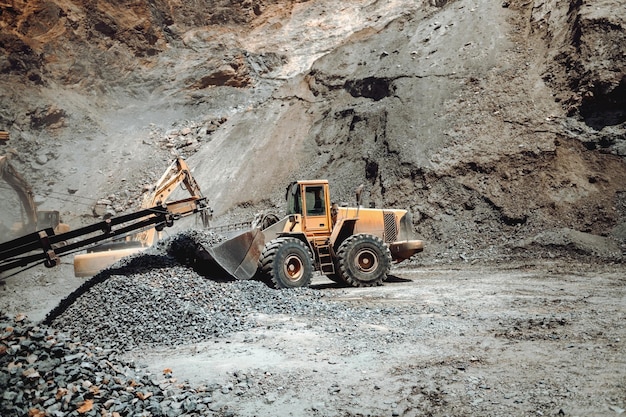 Maquinaria industrial en el sitio de la cantera de mineral excavadora de servicio pesado que mueve grava y rocas