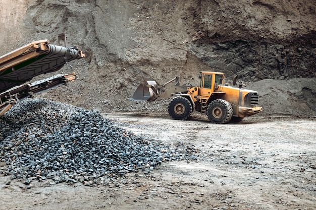 Maquinaria industrial en el sitio de la cantera de mineral excavadora de servicio pesado que mueve grava y rocas