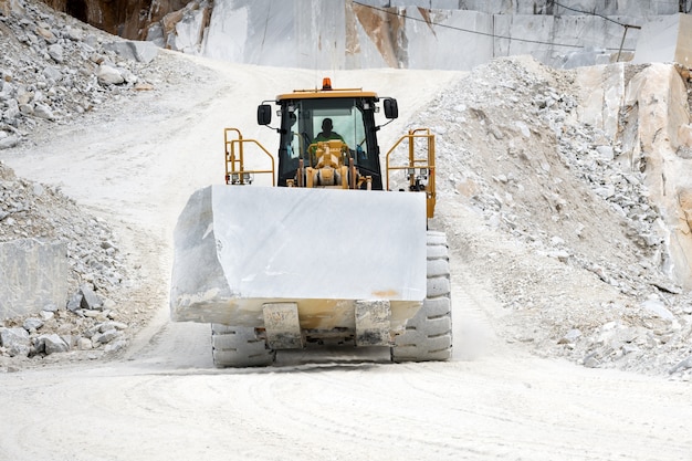 Maquinaria que move um bloco de mármore branco de carrara em uma pedreira na toscana, itália