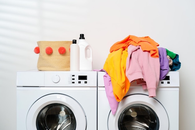 Máquinas de lavar blancas con ropa de colores en una lavandería