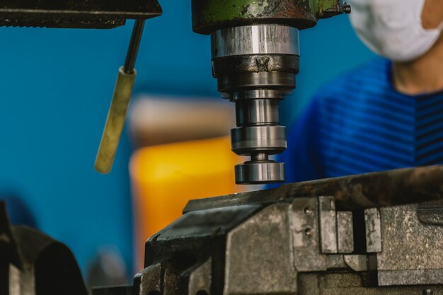 Maquinista profesional trabajando con fresadora en metalurgia.