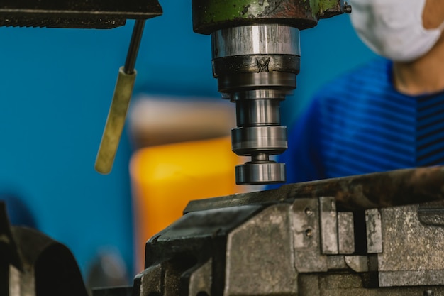 Foto maquinista profissional, trabalhando com a máquina de trituração na fábrica metalurgia