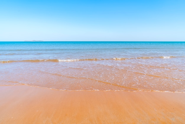 El mar y la arena bajo un cielo despejado