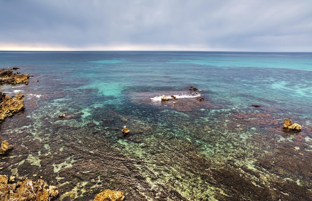 Mar azul al atardecer en la costa de Alghero Cerdeña