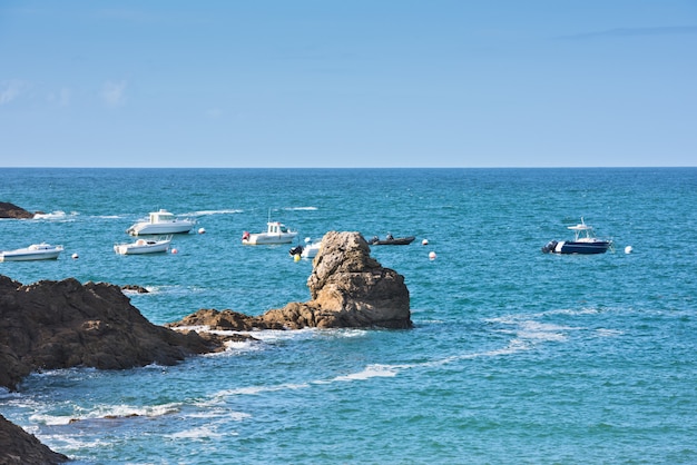 Mar azul brillante y barcos de pescadores en Bretaña, Francia