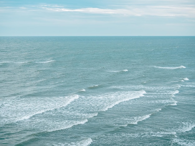 mar azul com ondas e nuvens em dia ensolarado