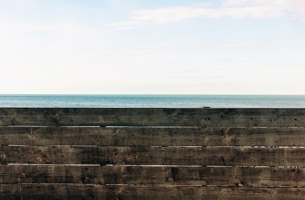 Mar azul detrás de una valla de madera