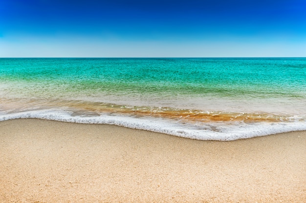 Mar azul e praia de areia branca no céu azul