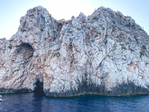 El mar azul con espuma blanca cerca del agua es una roca de piedra blanca, un agujero está tallado en la piedra