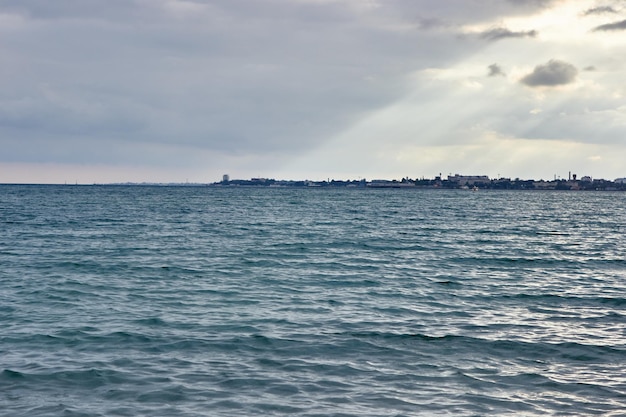 Mar azul por la noche con pequeñas olas Ondas en la superficie del agua La ciudad