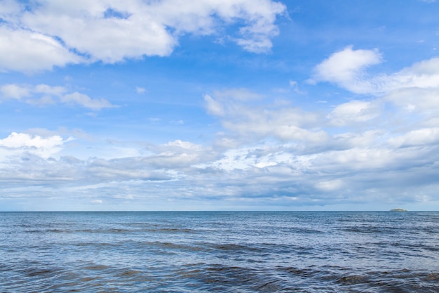 Mar azul con olas y cielo azul claro con nubes