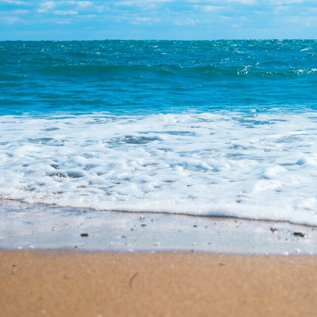 Foto mar azul y playa con arena dorada. fondo de vacaciones de verano