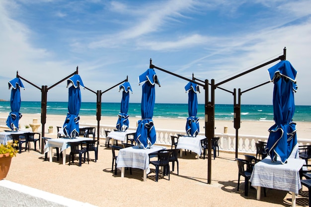 El mar azul, la playa y las sombrillas en la playa.