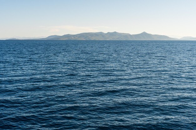 Mar azul profundo con montañas en el horizonte