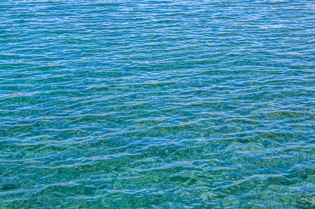 Mar azul en el resplandor del sol como fondo de la superficie Concepto de vacaciones de verano