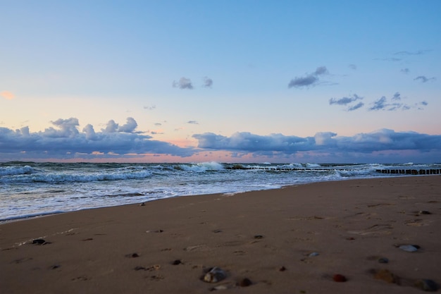 Mar báltico contra o dramático céu nublado ao pôr do sol