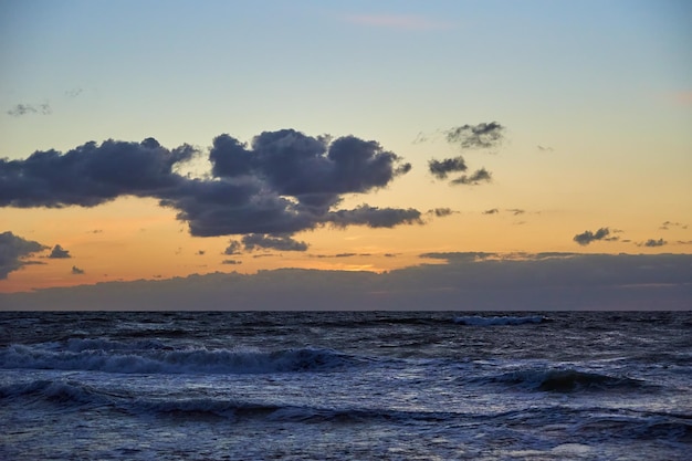 Mar Báltico contra o dramático céu nublado ao pôr do sol