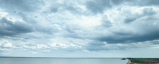 Mar en calma azul y cielo con nubes. Espectacular cielo antes de la tormenta con nubes y huecos.