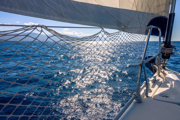 Mar en calma. La vela de estay del yate hace una sombra del sol brillante