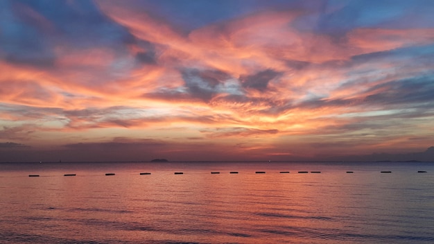 Mar calmo com céu colorido ao pôr do sol e nuvens de meditação no fundo do oceano