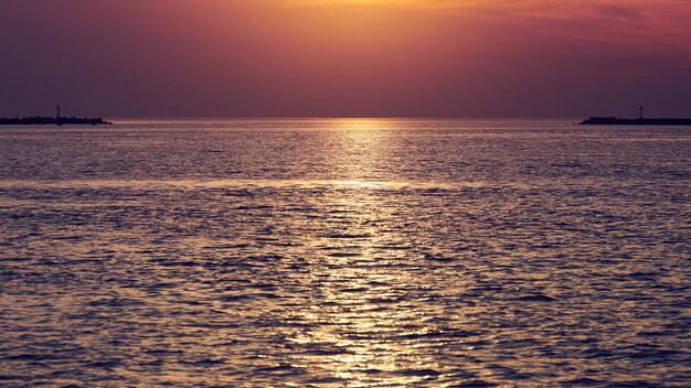 Mar calmo com céu pôr do sol, bela vista panorâmica. Incrível céu dramático do sol com variedade de cores e matizes do sol nascente e reflexo na água. Oceano de meditação, paisagem marítima romântica e tranquila